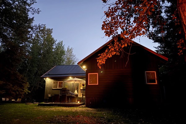 Aspen Acre glowing warmly at night in the quiet forest setting