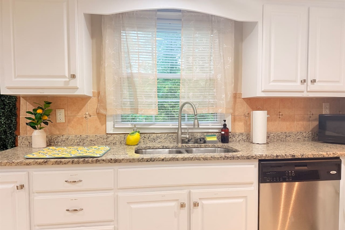Large sink with window view adds brightness and a fresh feel to the kitchen’s prep and clean-up area. 