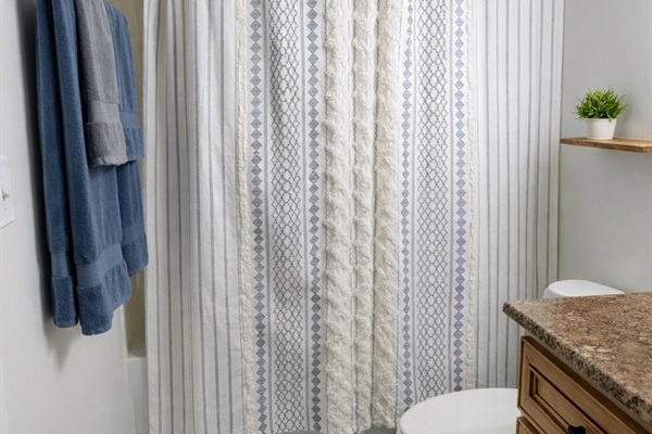 Bright, clean bathroom with full tub/shower