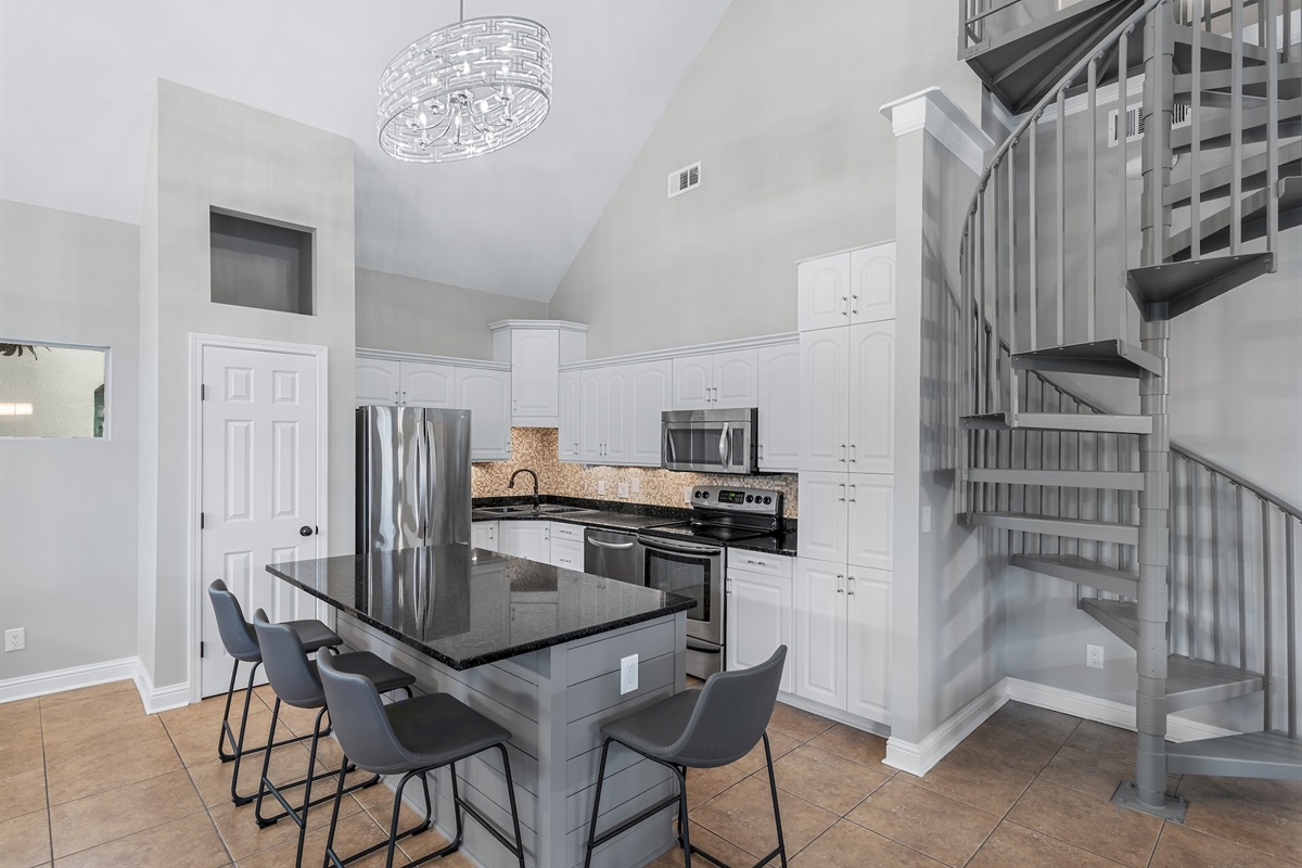 Gourmet kitchen with stainless‑steel appliances and breakfast bar seating