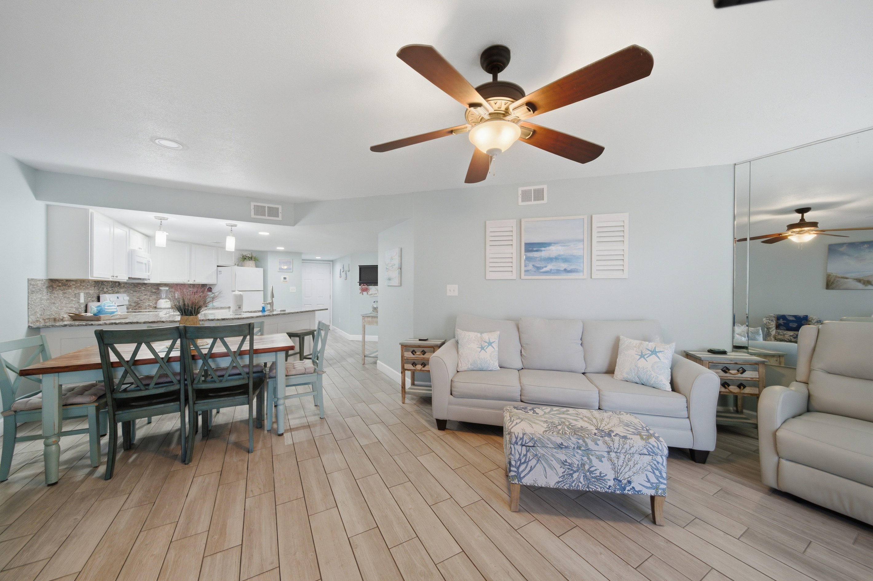 Open-concept living, dining, and kitchen area with wood flooring throughout
