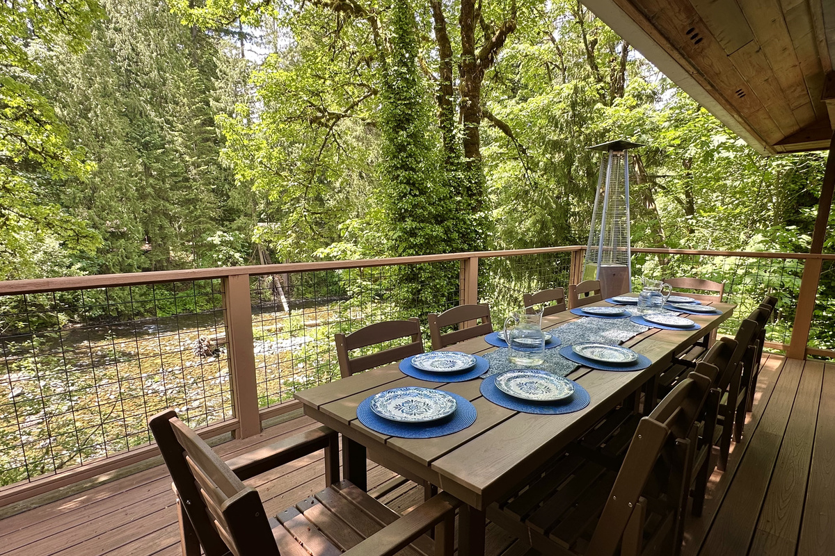 Bring everyone together to soak up the river, sun and surrounding trees on 3 large decks overlooking the Salmon River from the main house. This deck is just off the Great Room and has plenty of room to eat outside. There's also a covered grilling station. 