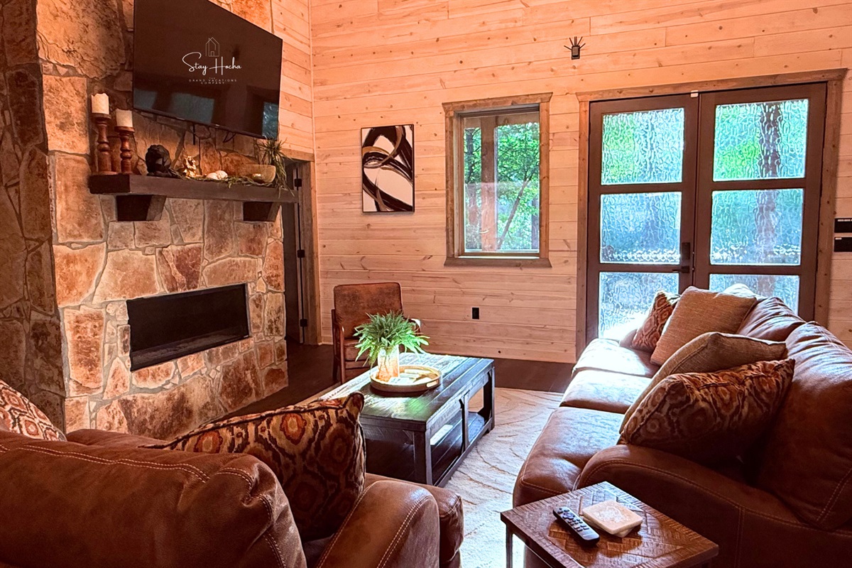 Cozy living room with stone fireplace & nature views