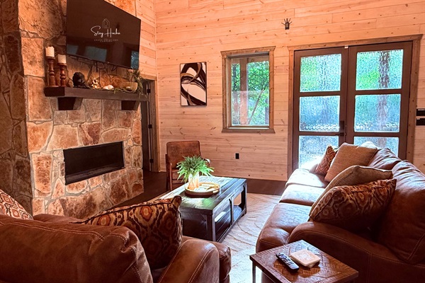 Cozy living room with stone fireplace & nature views