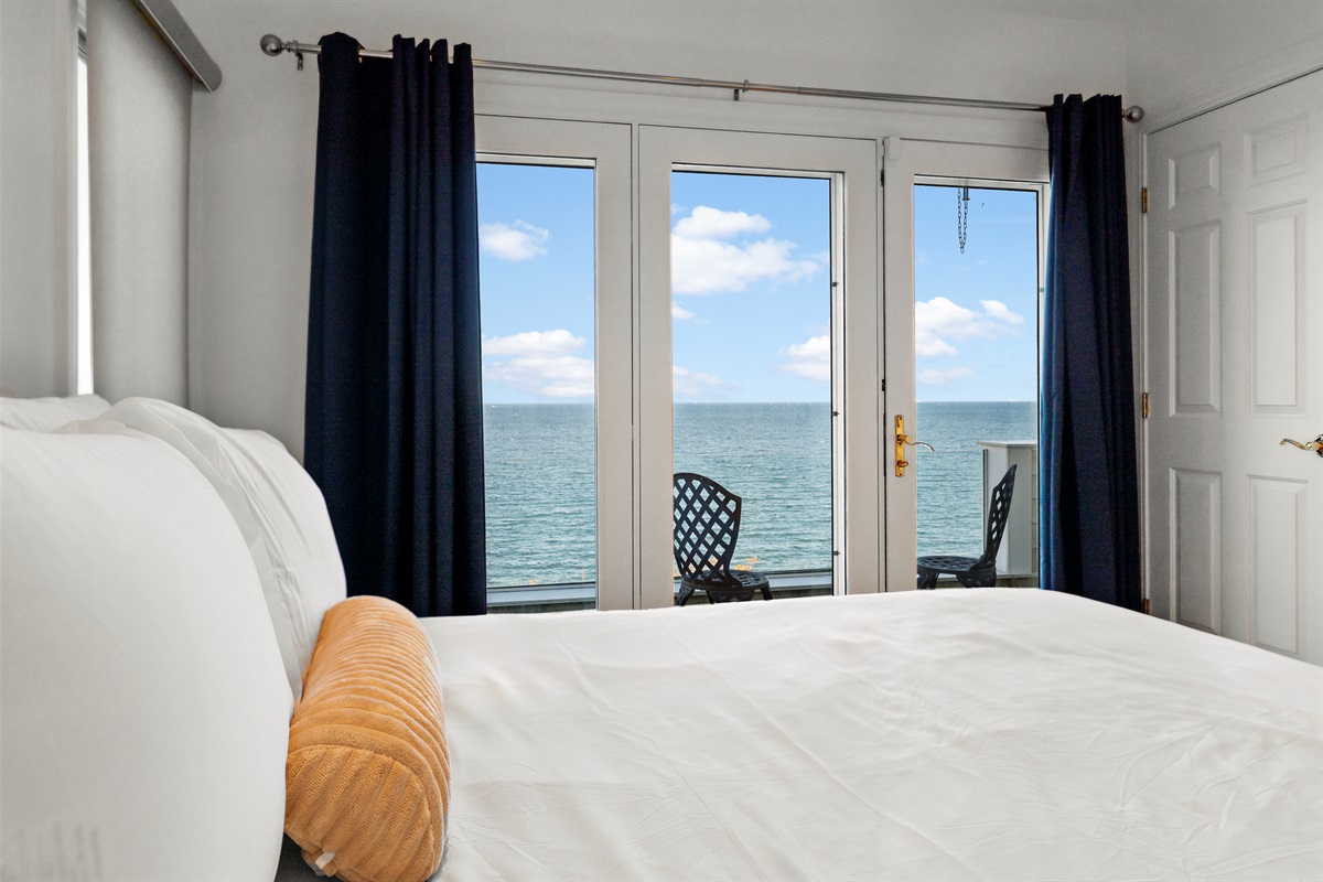 Second-level bedroom featuring a queen bed and serene ocean vistas.