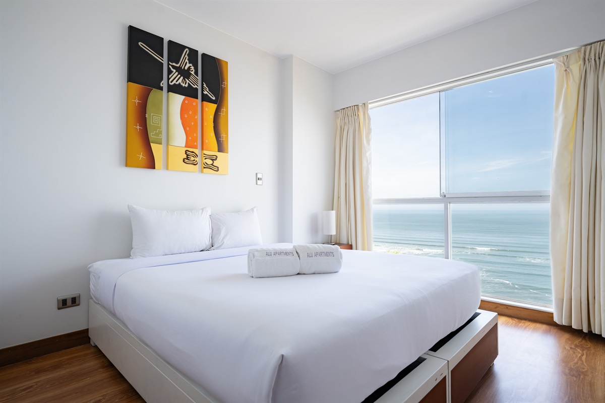 Modern comfort with a queen bed and unforgettable views of the ocean and Malecón  /  Cama queen y vistas inolvidables al océano y al malecón