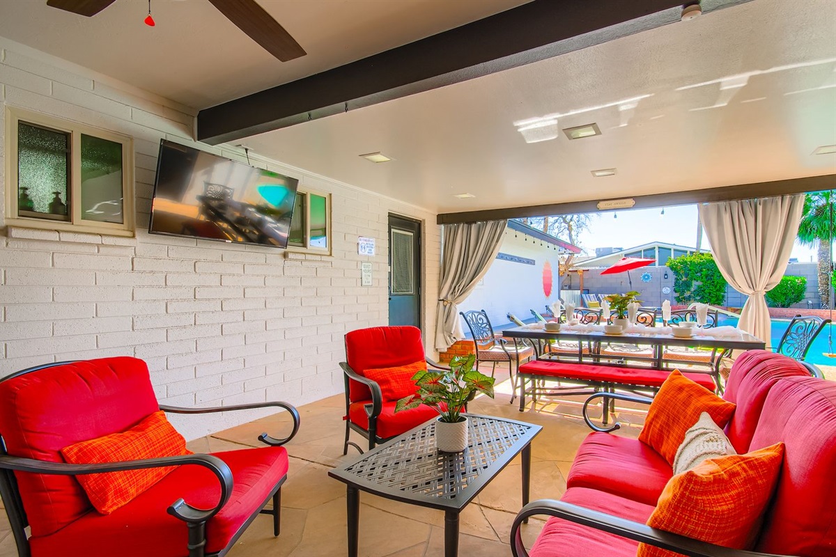 Outdoor seating for 4 in chairs and 10 at Dining table looking at the outdoor TV and pool