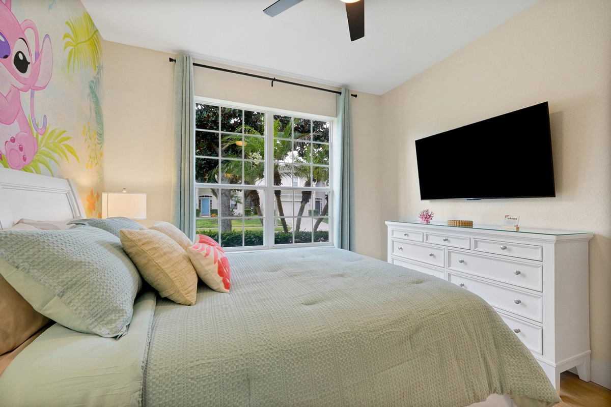 Stitch Queen Retreat: Bright queen bedroom featuring TV, tropical décor and a playful Stitch & Angel mural.