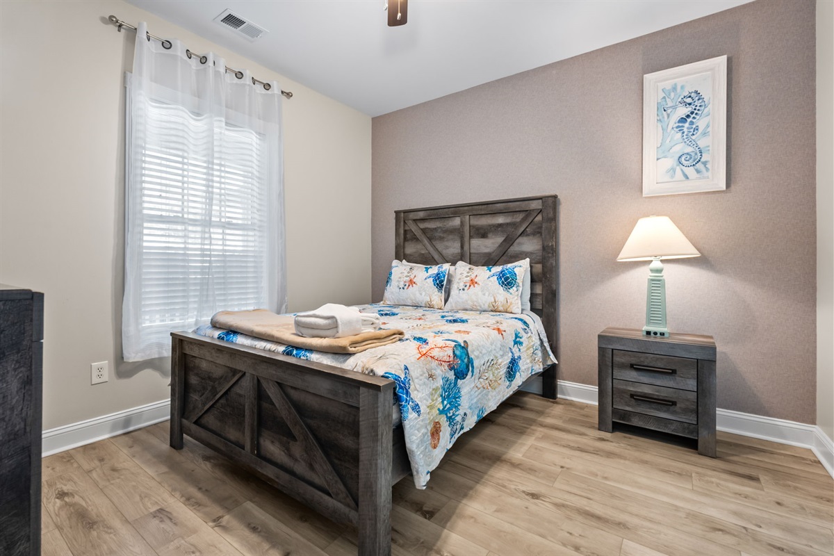 Elegant queen-sized master bedroom with a serene white theme and a large window filling the space with natural light—a perfect retreat for rest and relaxation.