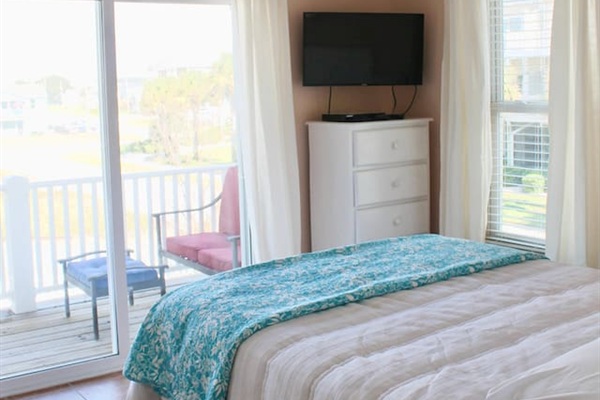 2nd floor guest bedroom #1. Back of house. Balcony access. Queen bed. TV. Closet + dresser for clothes.