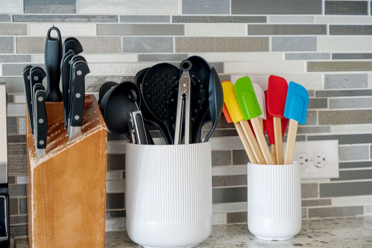 Discover the well-equipped kitchen with a variety of utensils neatly organized on the countertop, enhancing your cooking experience.