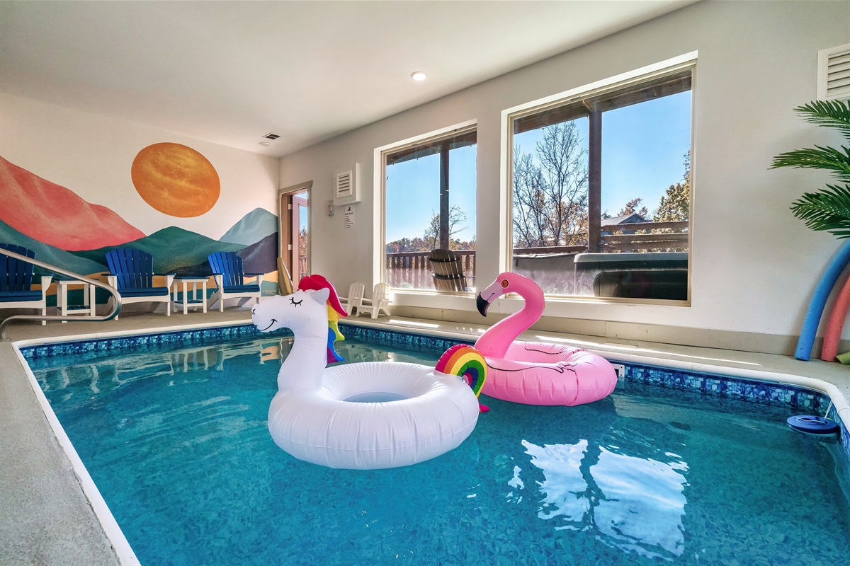 Relax at the indoor heated pool with a custom mural and large windows offering an incredible view