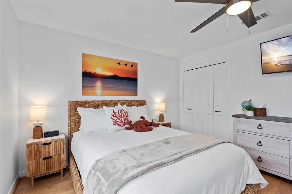 This bedroom offers a cozy retreat with a wall-mounted TV, perfect for unwinding after a day at the beach.