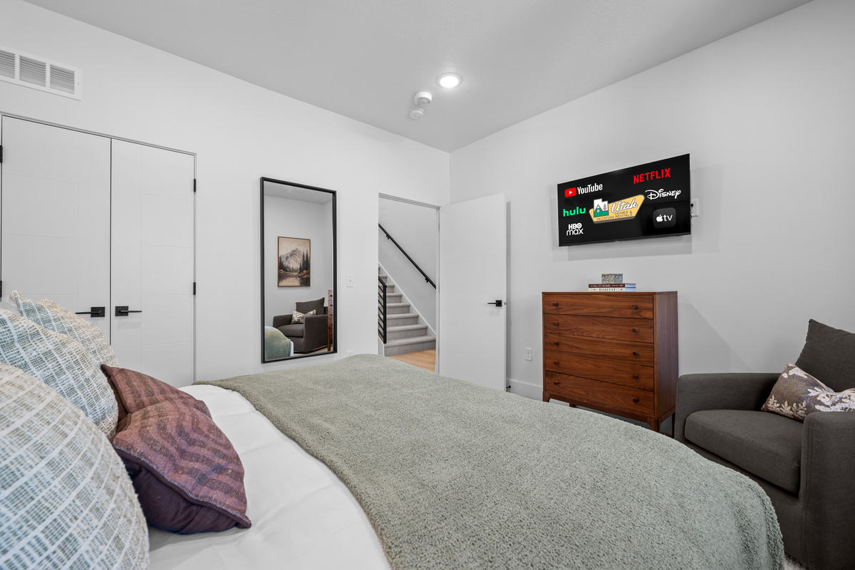 Main-level bedroom with king bed, Smart TV, and double closet.