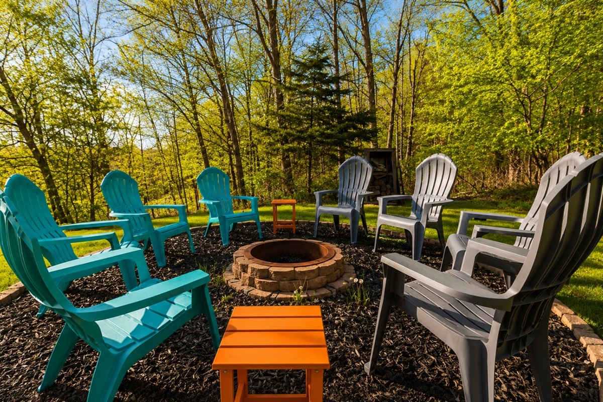 Gather around the fire pit for unforgettable evenings in this charming outdoor seating area, nestled among vibrant greenery. Perfect for any season! 