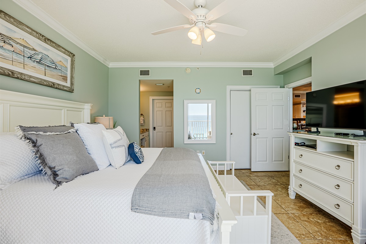 Master bedroom with king bed, ceiling fan, smart TV, clothing storage and ensuite bathroom