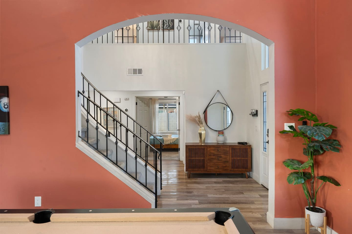 rand entry foyer with soaring ceilings, arched architectural details, and direct stair access.