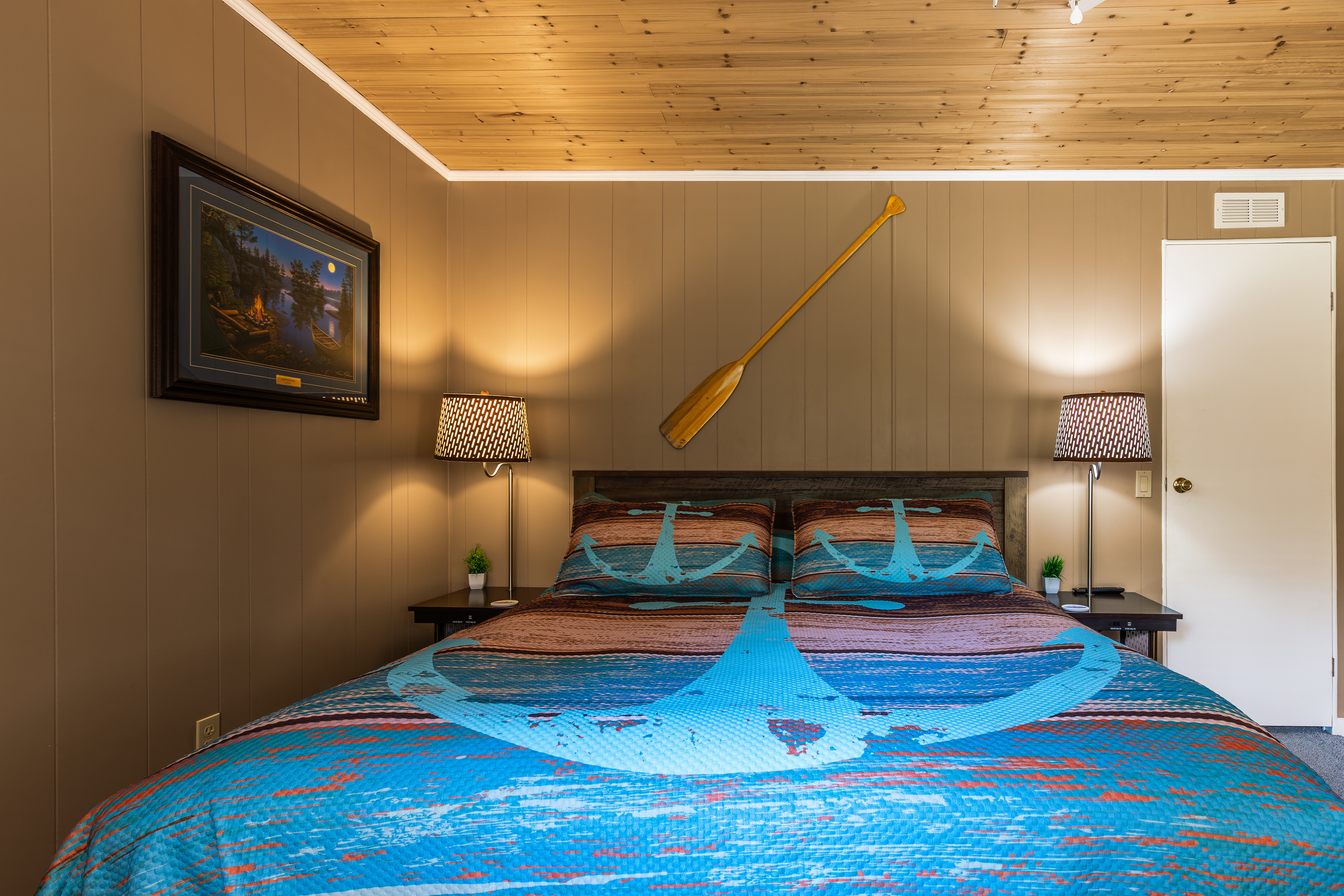 Unwind in the lake-inspired king bedroom with warm lighting, bedside tables, and plenty of room to settle in.