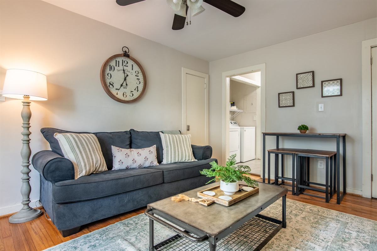 Comfortable seating area under ceiling fan lighting, with a peek into the adjacent kitchen and hallway.