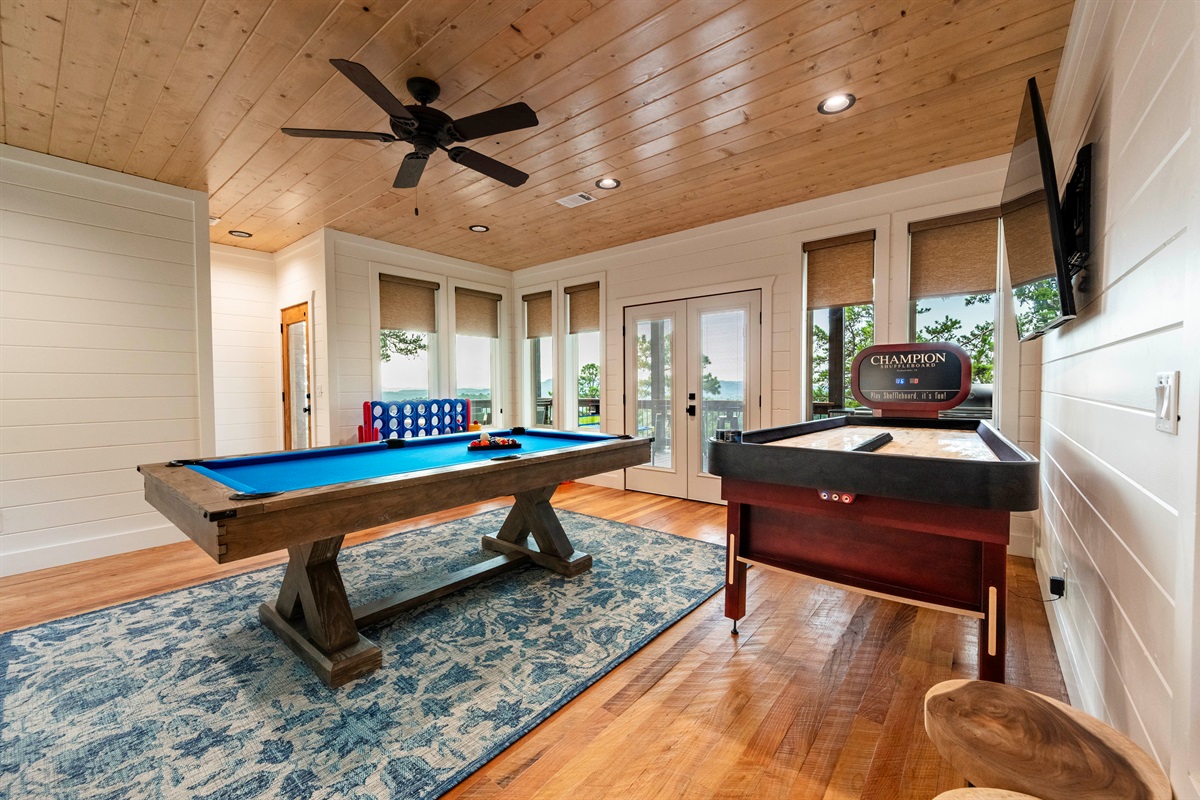 Game room featuring pool table, shuffleboard, and a bright entertainment space