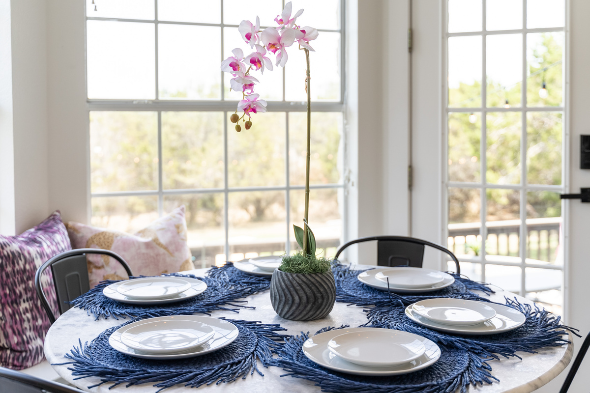 Sunlit breakfast nook with a stylish blue table setting for casual dining.