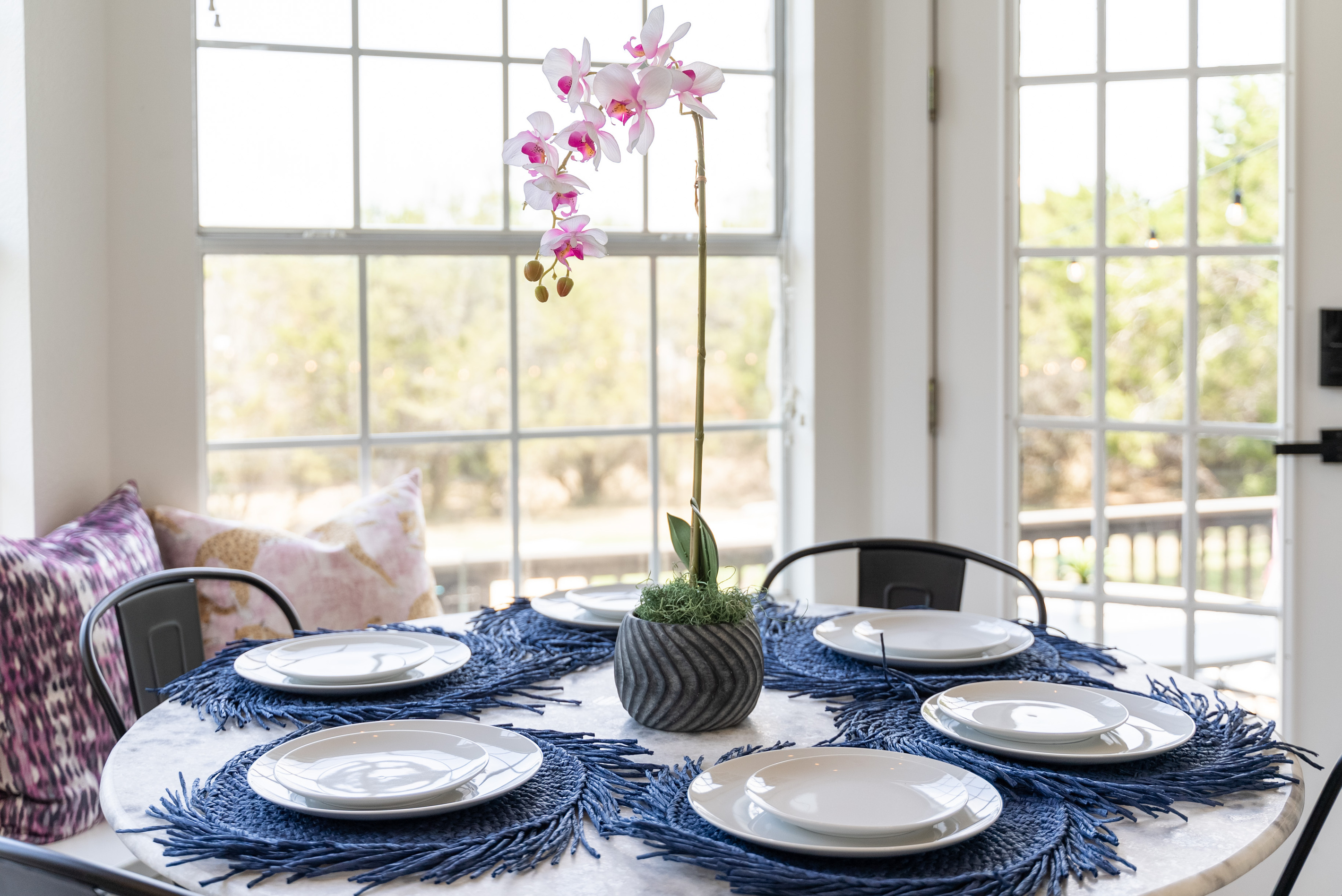 Sunlit breakfast nook with a stylish blue table setting for casual dining.