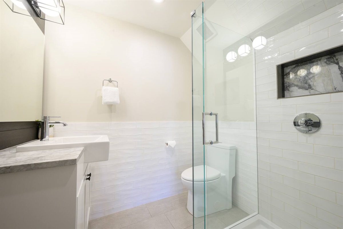 Ensuite Bathroom #3 features a bright and beautifully tiled shower complete with marble inset. 