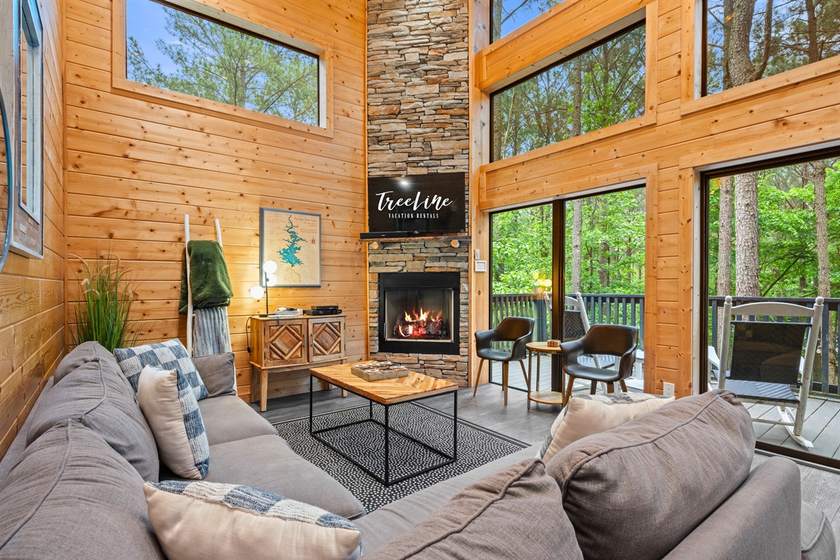 With its tall ceilings, large windows, and stone fireplace, this living area is the perfect place to relax and reconnect after a day outdoors.