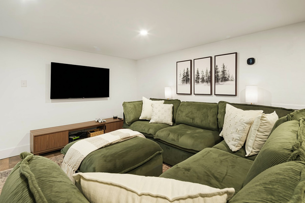 This area of the basement has a super comfortable sectional and ottoman. Perfect for movie watching or playing games.