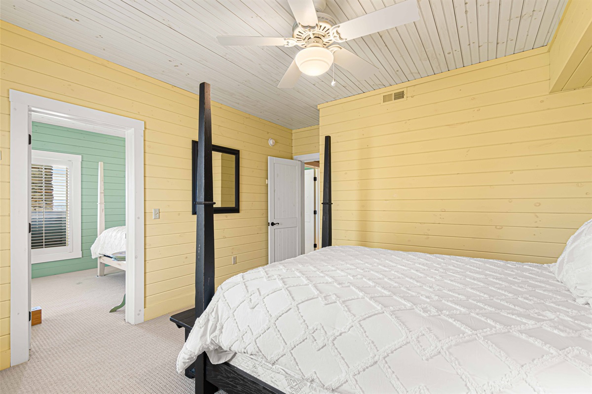 Downstairs Queen Bedroom 3: Vibrant yellow walls and plush bedding create a restful getaway. Unwind here!
