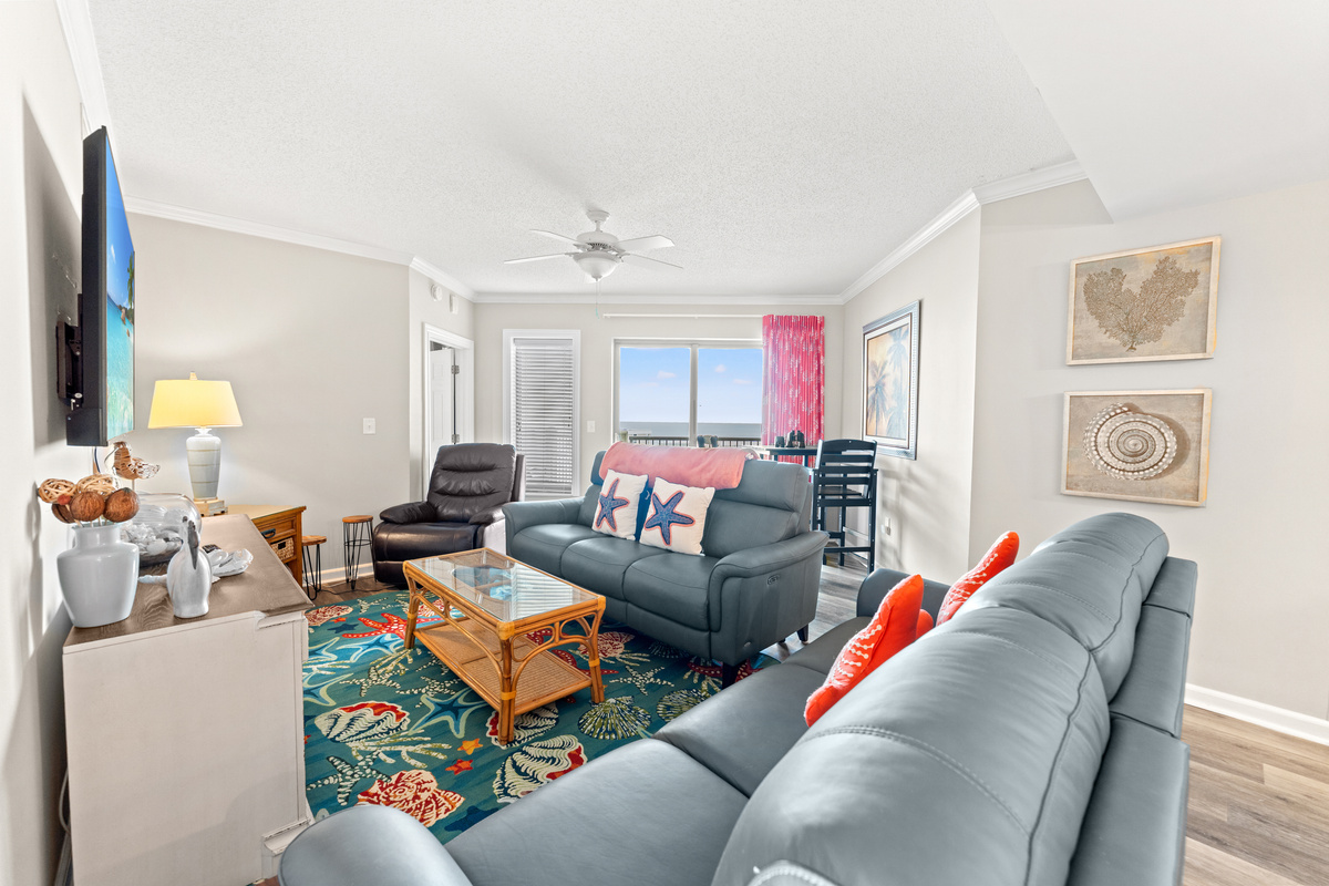 Living room are with plenty of seating and large TV with balcony access