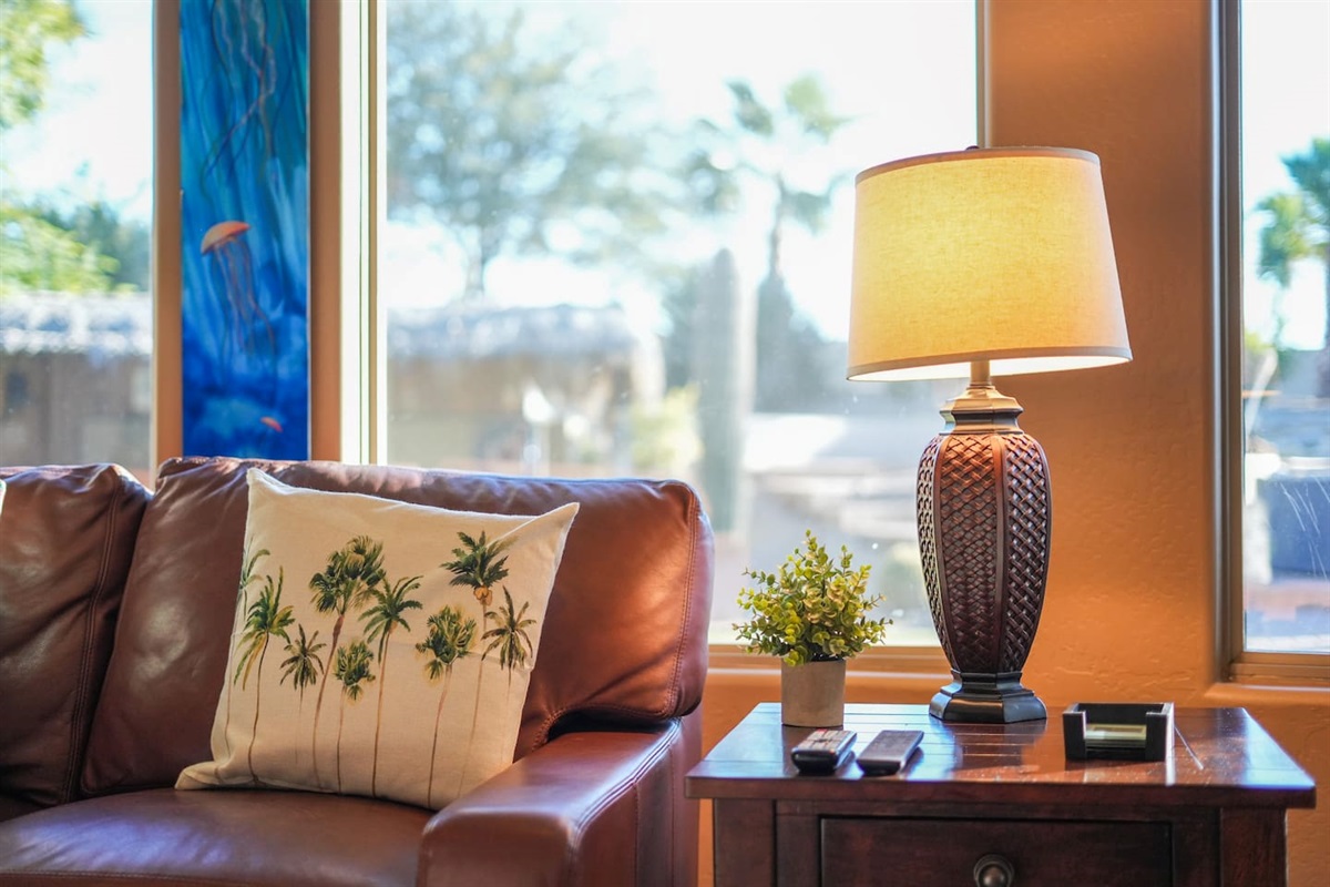 Thoughtfully styled seating area with side tables, soft lighting, and backyard views