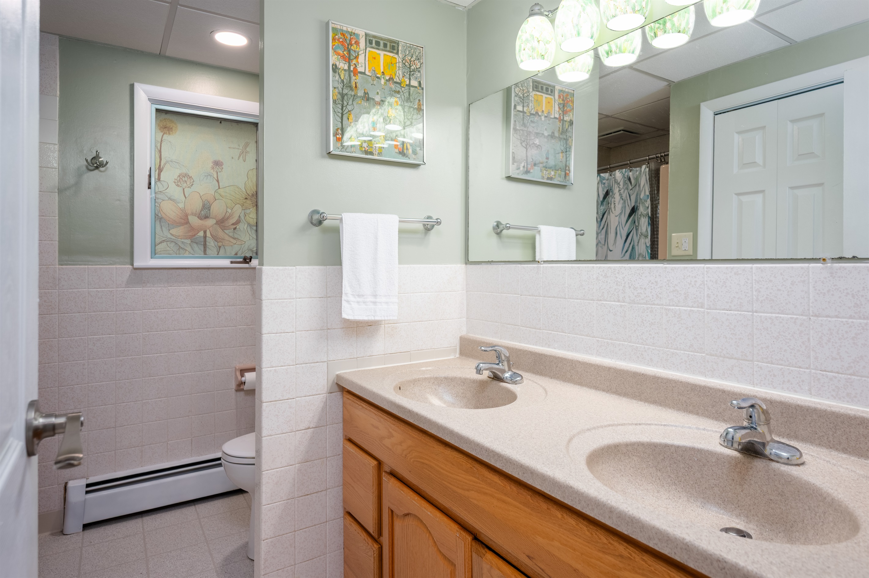 Main level full bathroom with double vanity and shower/tub combo