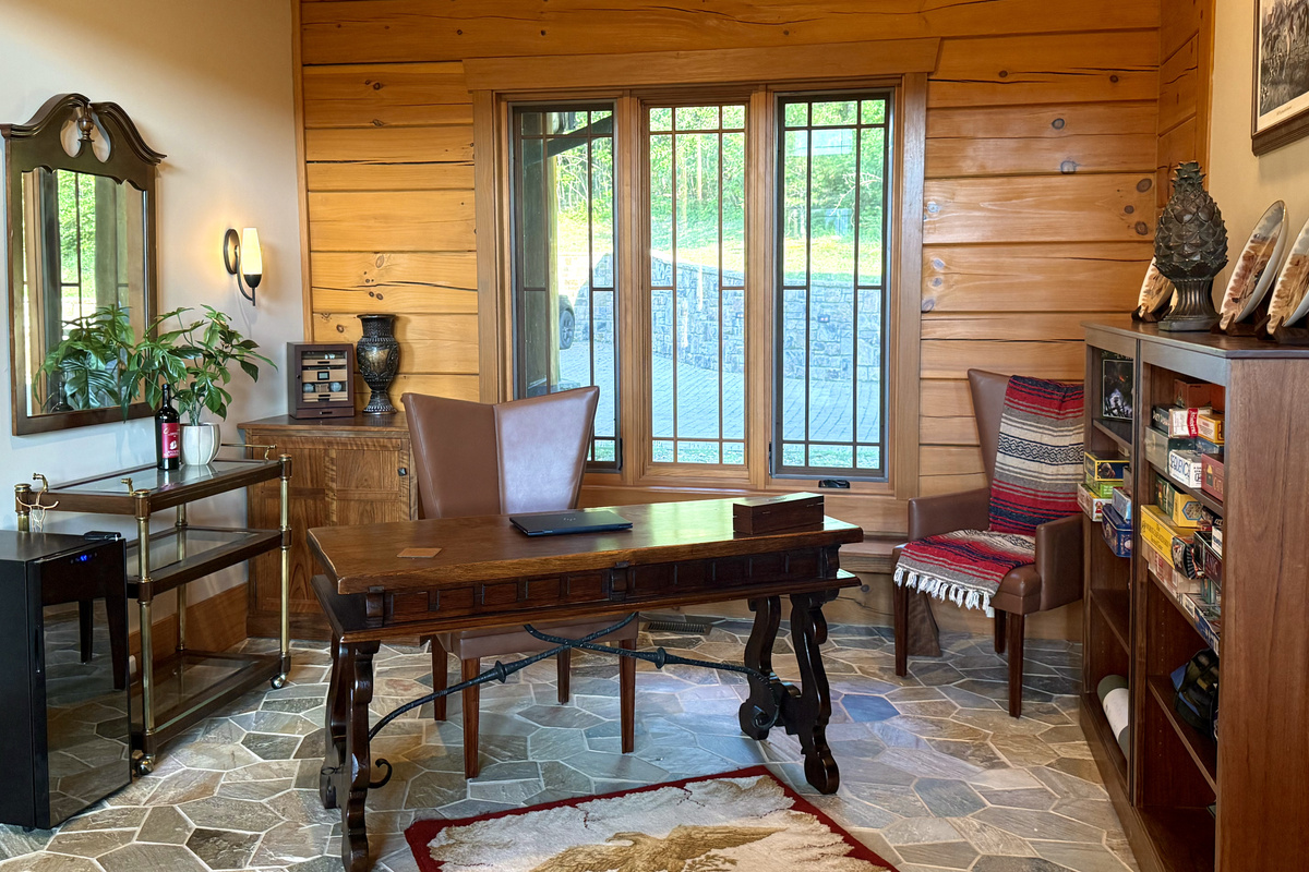 Versatile office with desk and shelves full of games, ideal for remote work or family fun.