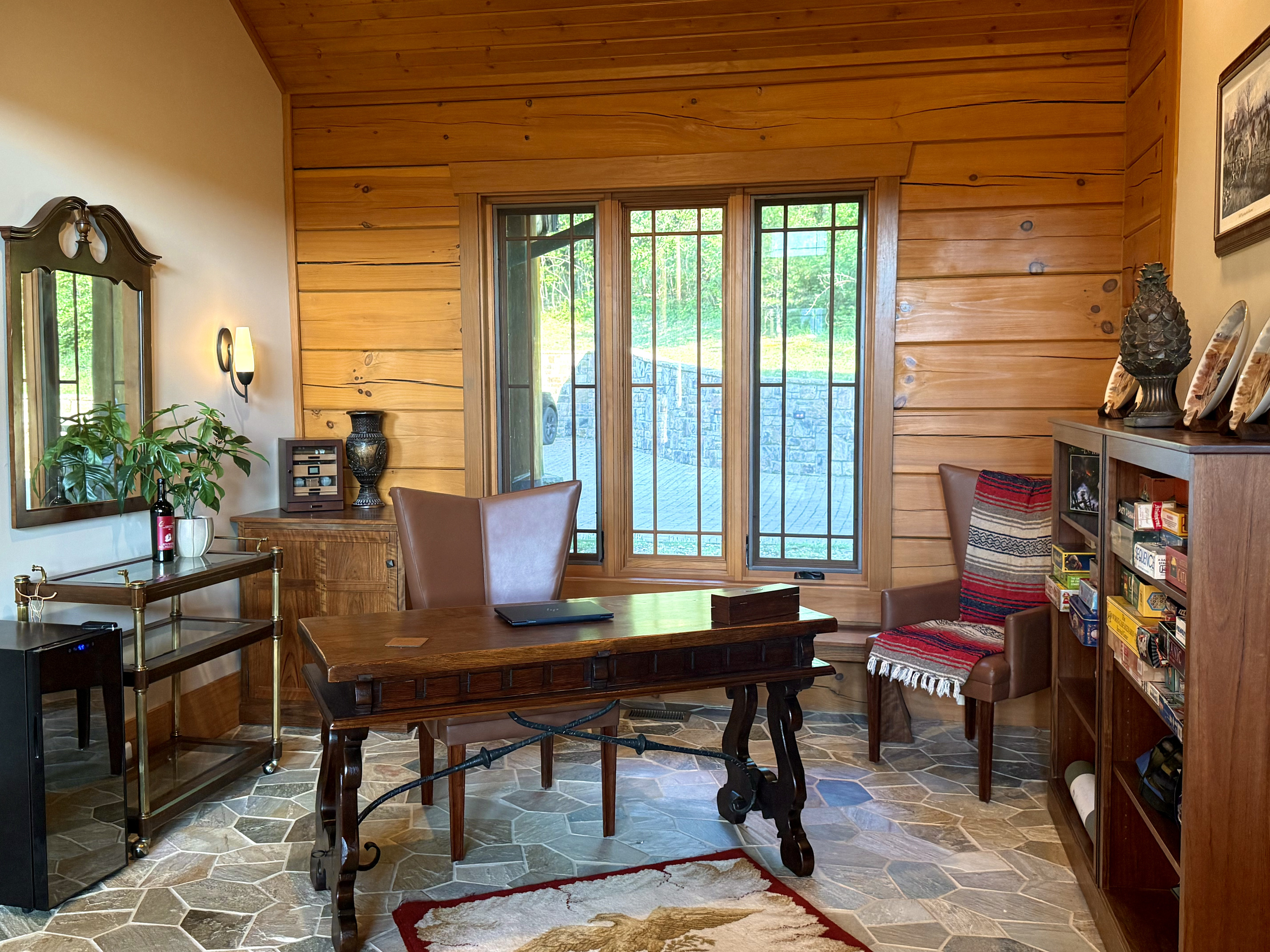 Versatile office with desk and shelves full of games, ideal for remote work or family fun.