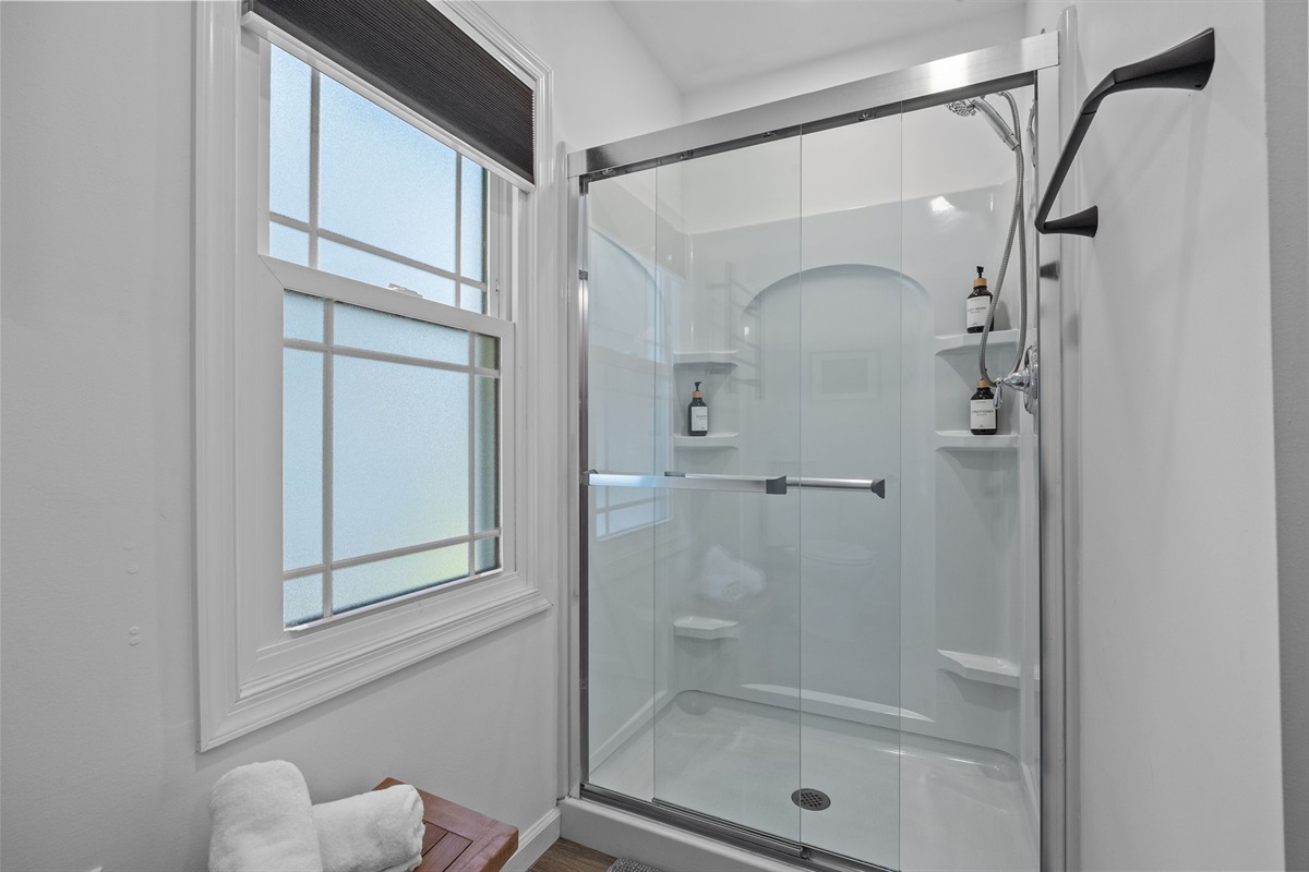 Private master bathroom with a spacious shower, fresh towels, and a clean, relaxing feel