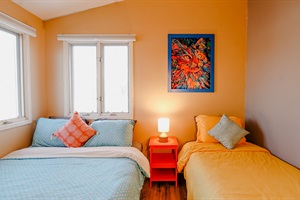 A room thoughtfully furnished with both a queen bed and a single bed, offering flexible sleeping arrangements for families or guests, maximizing comfort and space