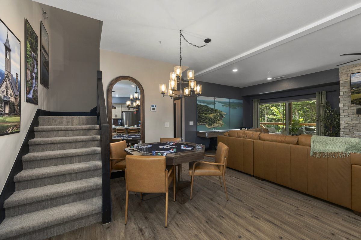Chandelier-lit dining flows past the staircase into the living room beyond.
