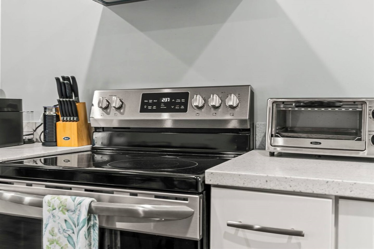 Close-up of the cooking zone with updated appliances, clean countertops, and thoughtful kitchen essentials.