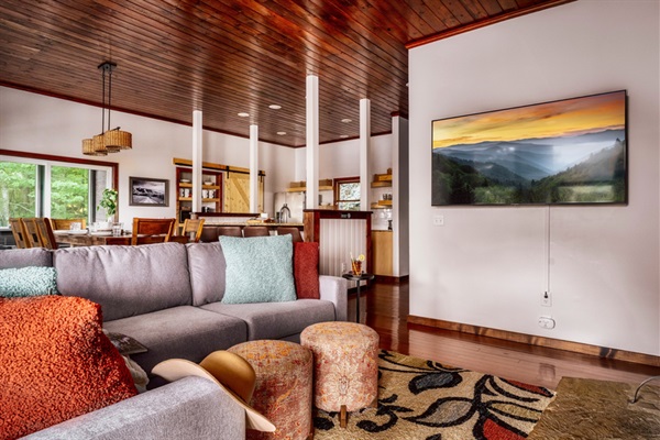 Spacious living room with sectional sofa, smart TV, and mountain views.