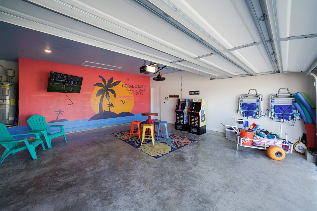 Spacious garage with bikes, TV, arcade, golf cart, and beach gear.