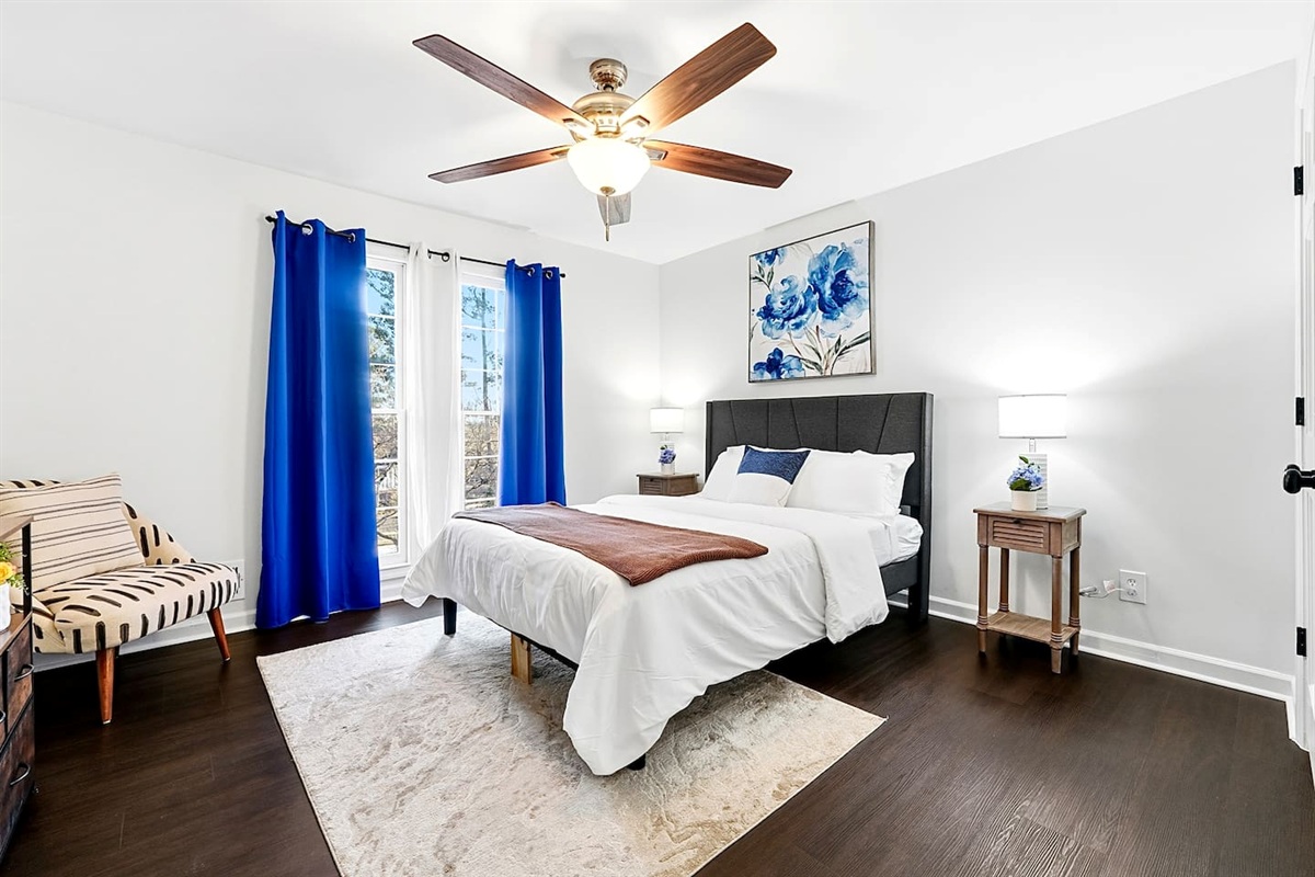 Upstairs bedroom located to the right, featuring a floral-inspired design and a comfortable double bed. Includes a smart TV and easy access to a shared bathroom. This room includes 2 full-body towels, 2 washcloths, and 2 hand towels for your stay.