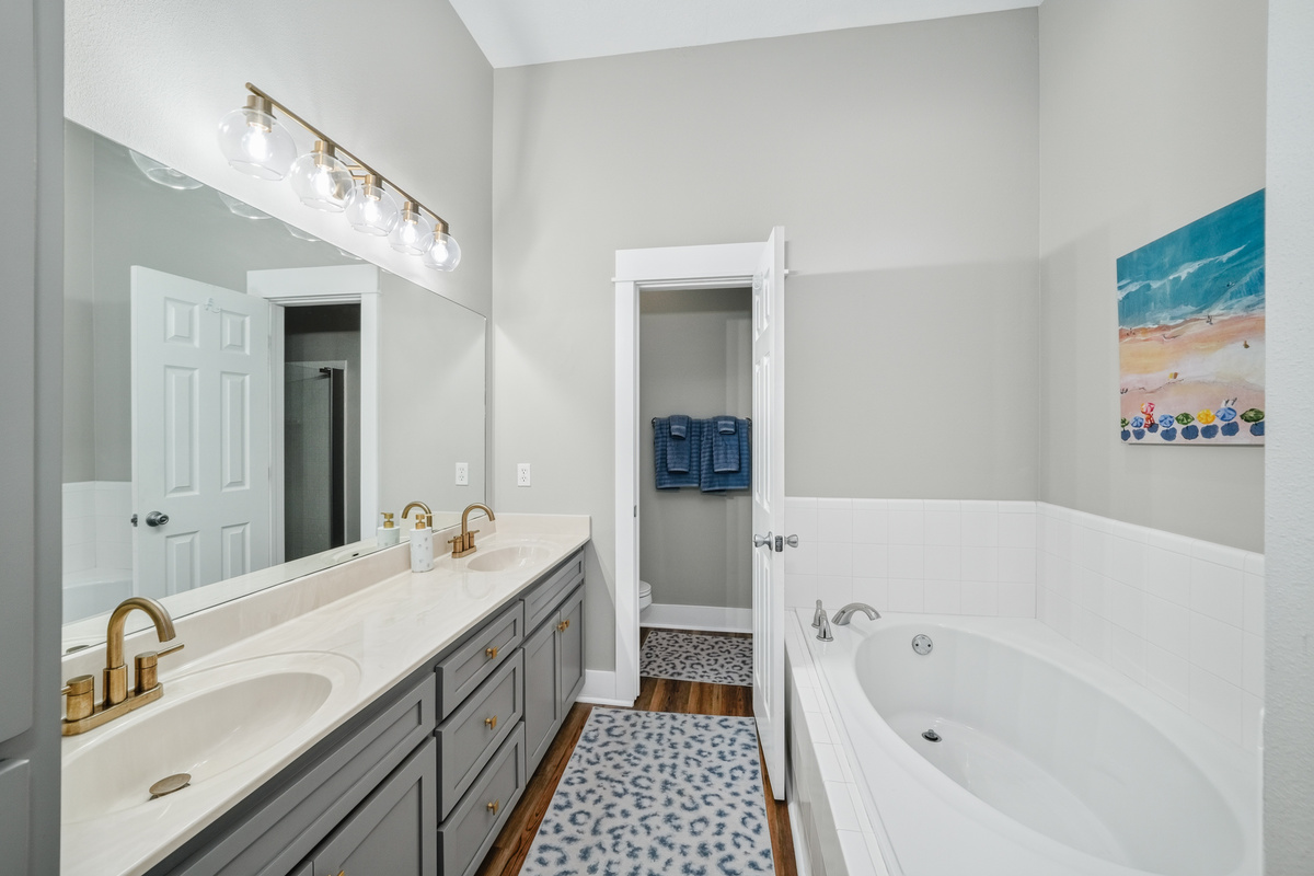 en-suite bathroom with dual vanities and a full soaking tub, offering extra space and convenience for a comfortable and relaxing day