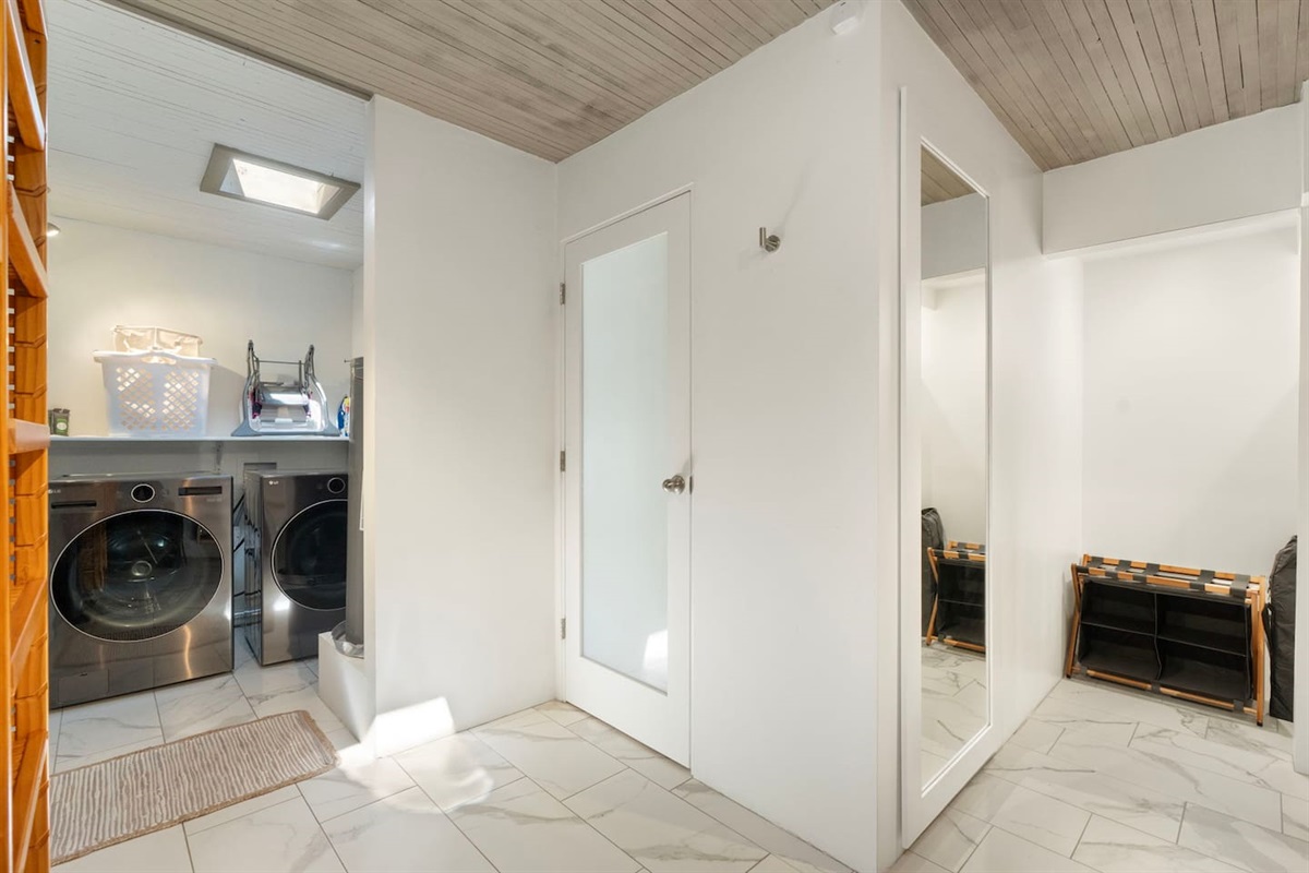 Convenient laundry area with full-size washer and dryer, ample shelving, and nearby closet space — making extended stays comfortable and practical.