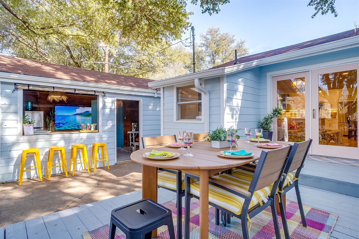 Outdoor bar seating, lounge space, and 72” pivoting TV