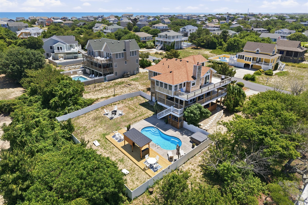 Elevated aerial view showcasing the home and spacious backyard retreat