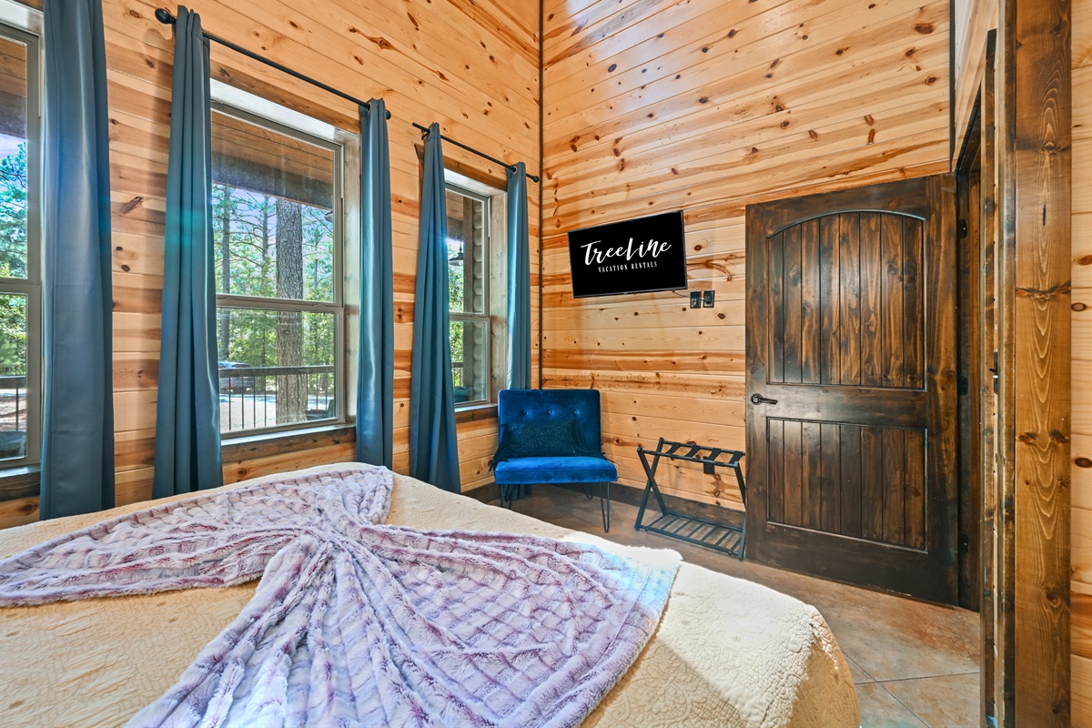 Wake up to wooded views in Bedroom 2, where cozy textures and cabin charm combine for comfort.