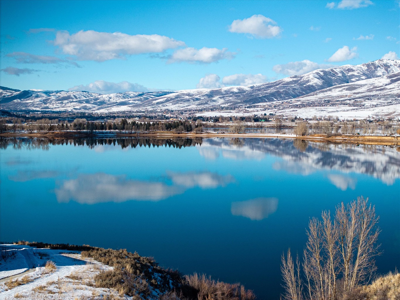 Peaceful lake views surrounded by snow-capped mountains.