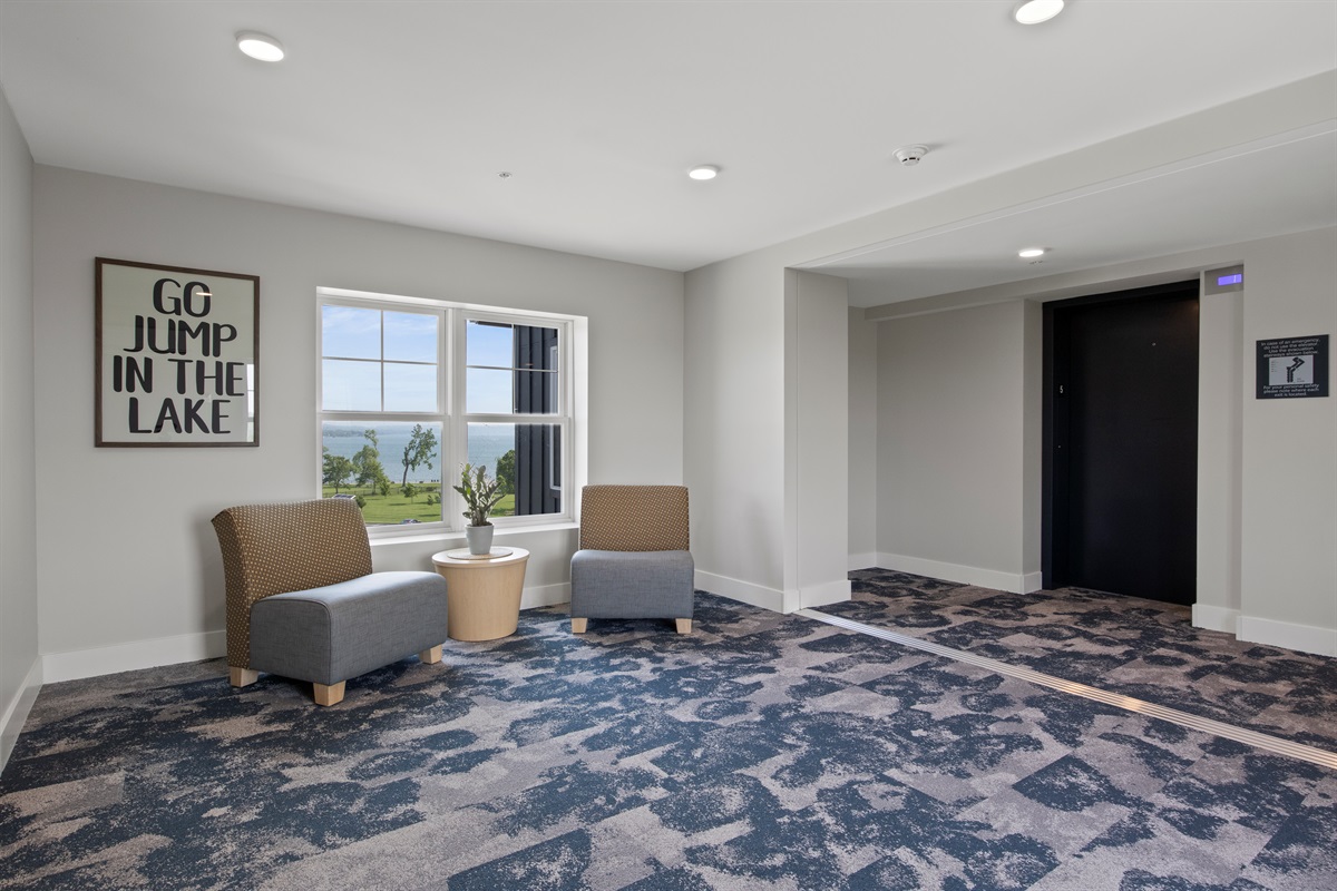 Relax in this stylish common area with comfy seating, lake views, and a fun reminder to soak up the adventure