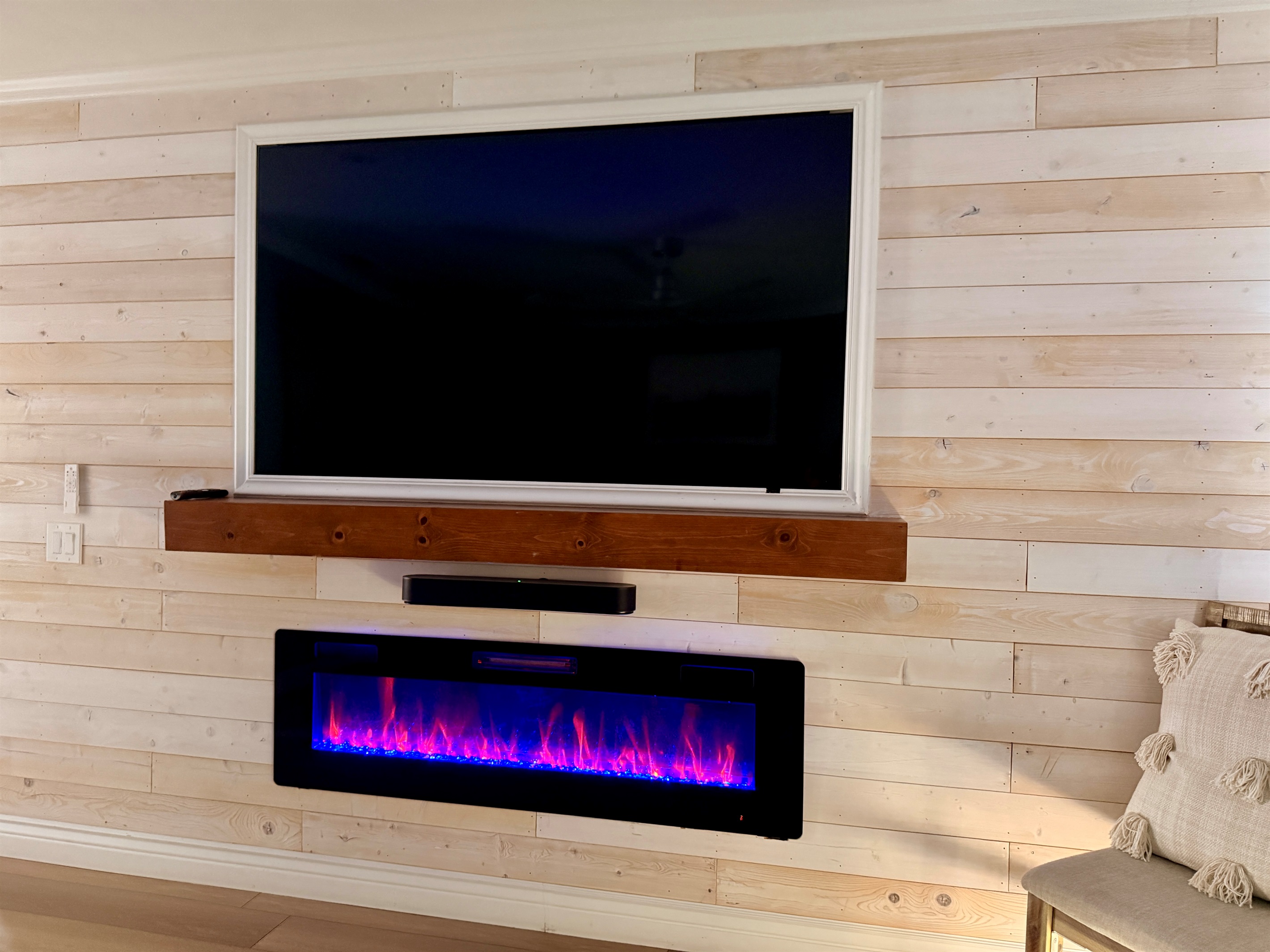 Primary bedroom entertainment center includes a 75" smart tv and electric fireplace.